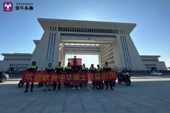 霍爾果斯通関地の前で記念寫真を撮影するバイクチーム