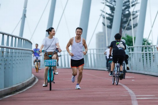妻の羅丹丹さん（寫真左）に勵まされながら成都天府緑道を走る陳さん（寫真右、撮影?瀋伯韓）。